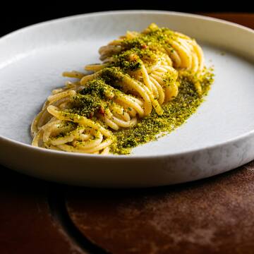 a plate of spaghetti with green sauce