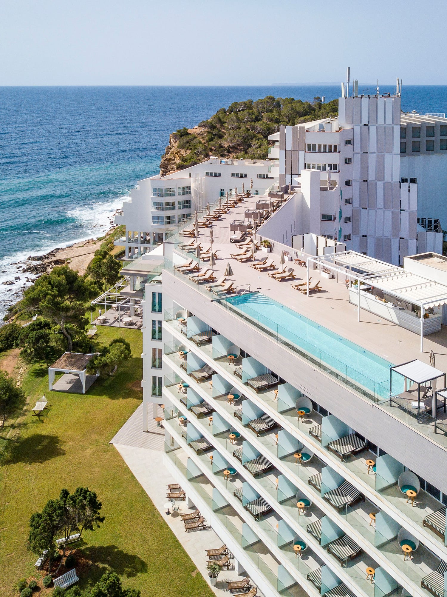 a building with a pool on top of it by the ocean