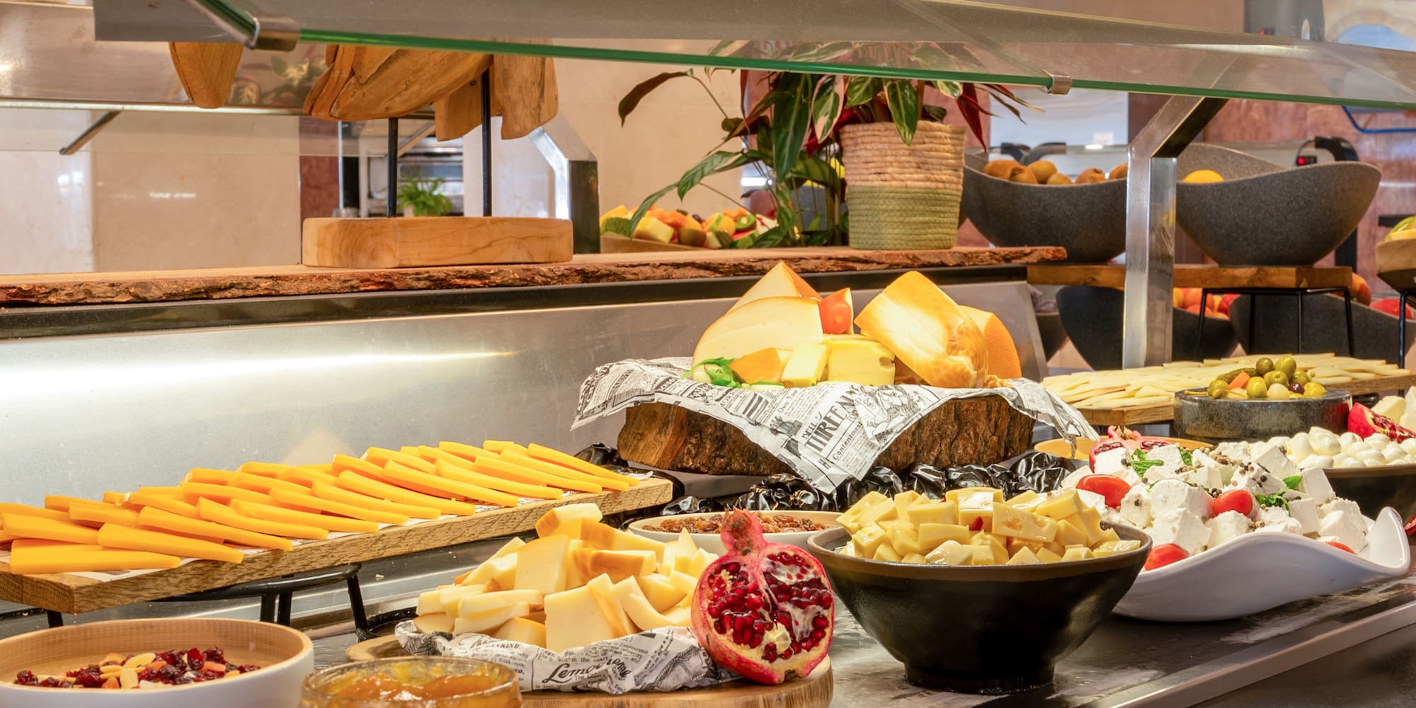 a buffet table with different types of cheeses and jams
