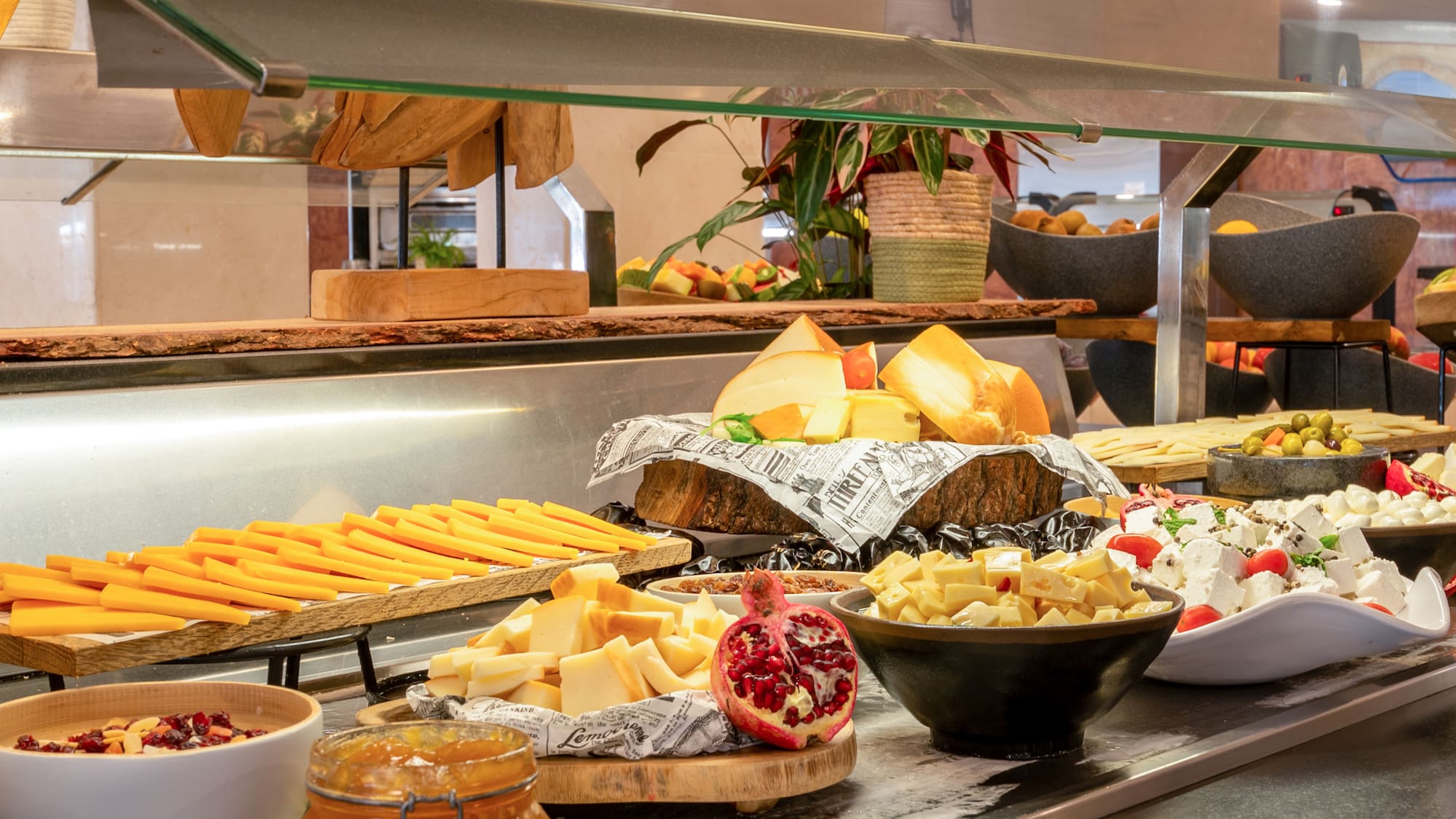 a buffet table with different types of cheeses and jams
