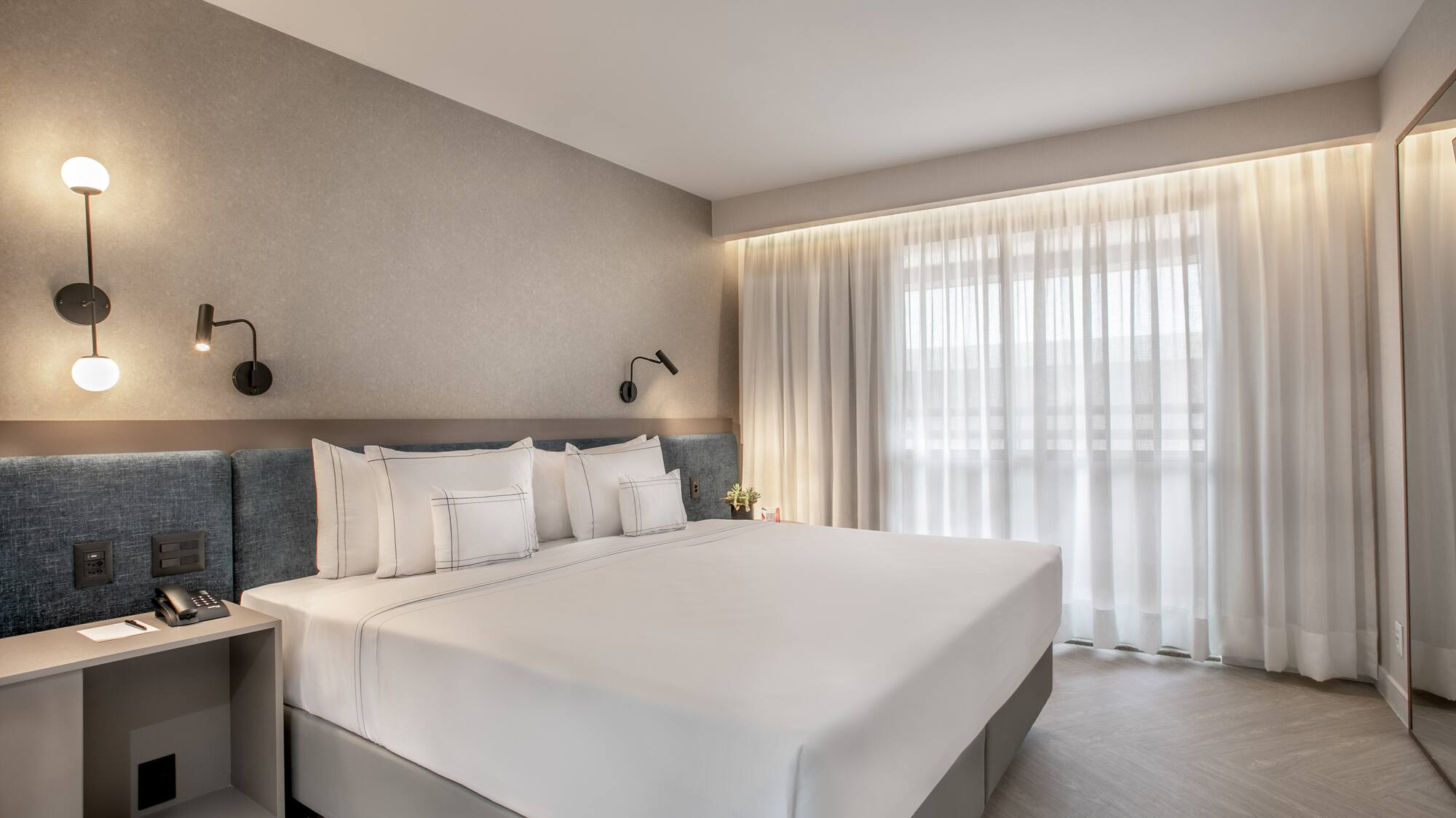 a bed with white sheets and pillows in a room