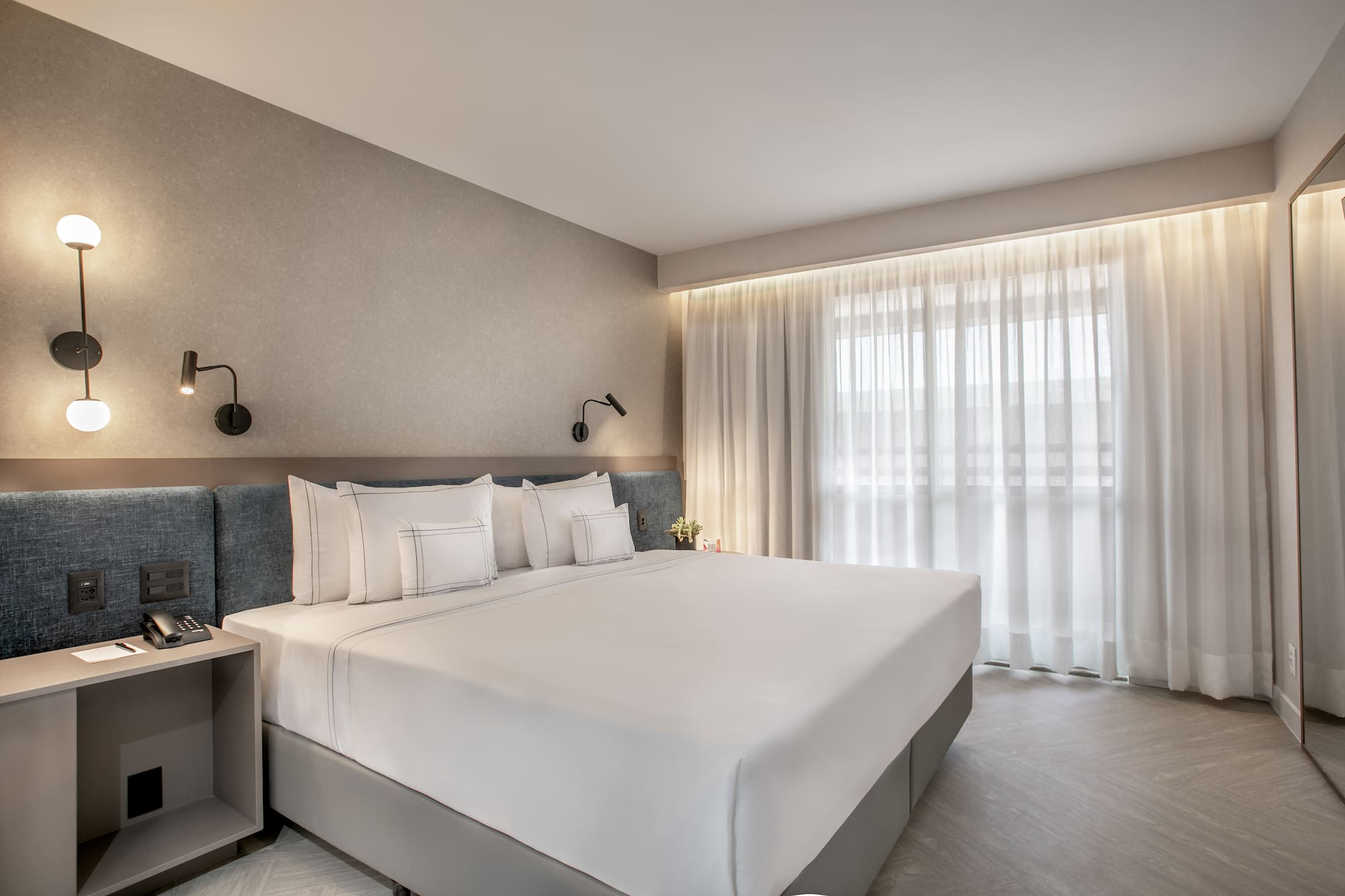 a bed with white sheets and pillows in a room