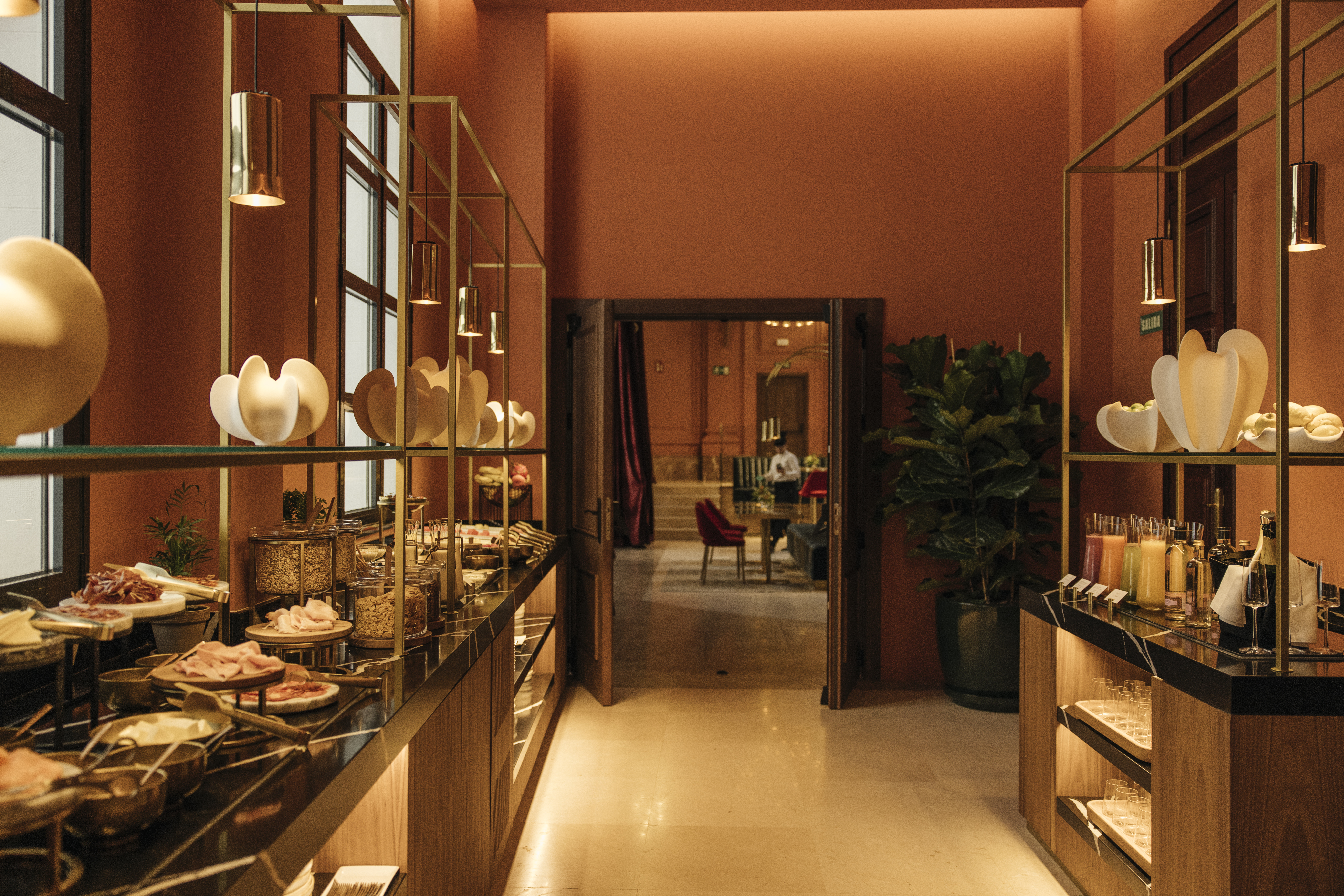 Modern hotel breakfast buffet with diverse food, juices, and stylish interior.