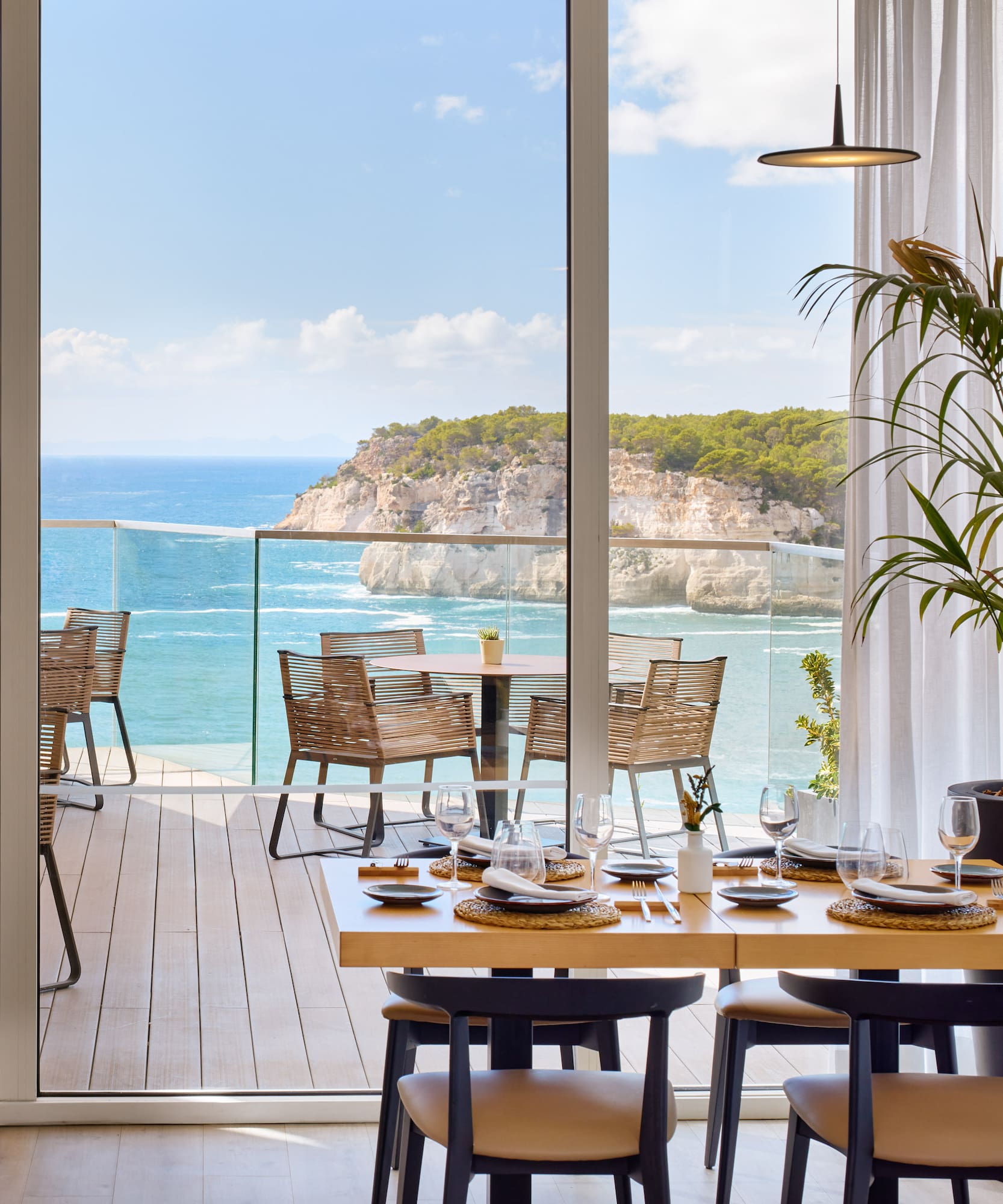 a dining room with a view of the ocean and a large window