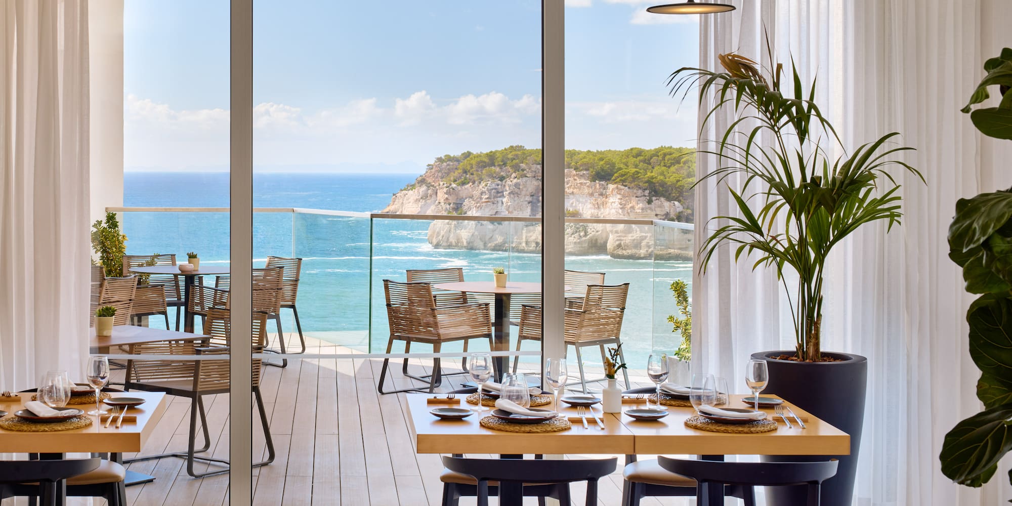 a dining room with a view of the ocean and a large window