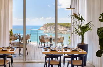 a dining room with a view of the ocean and a large window