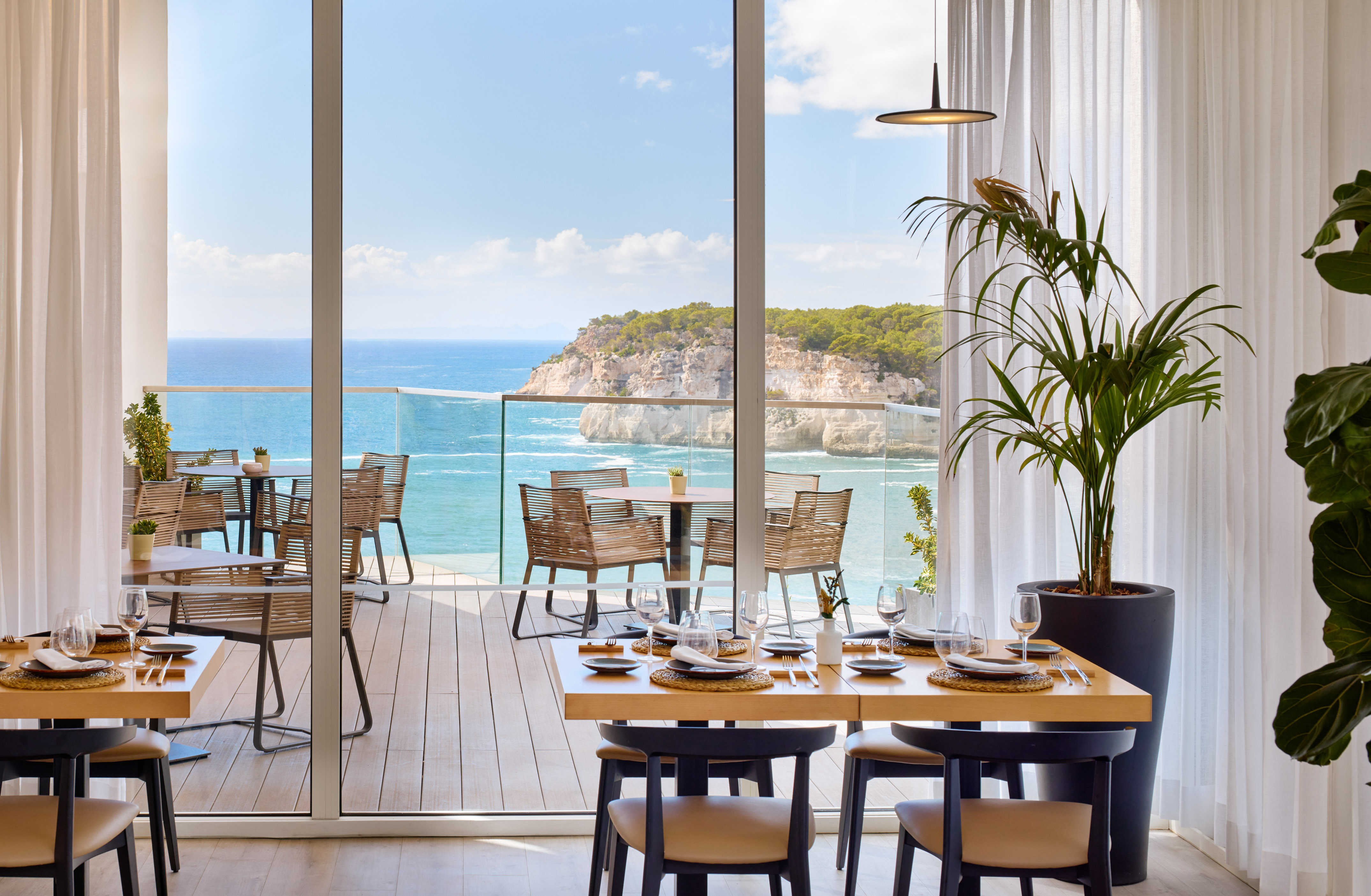 a dining room with a view of the ocean and a large window