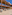 Modern resort outdoor patio and bar area with dining tables, wooden structure.