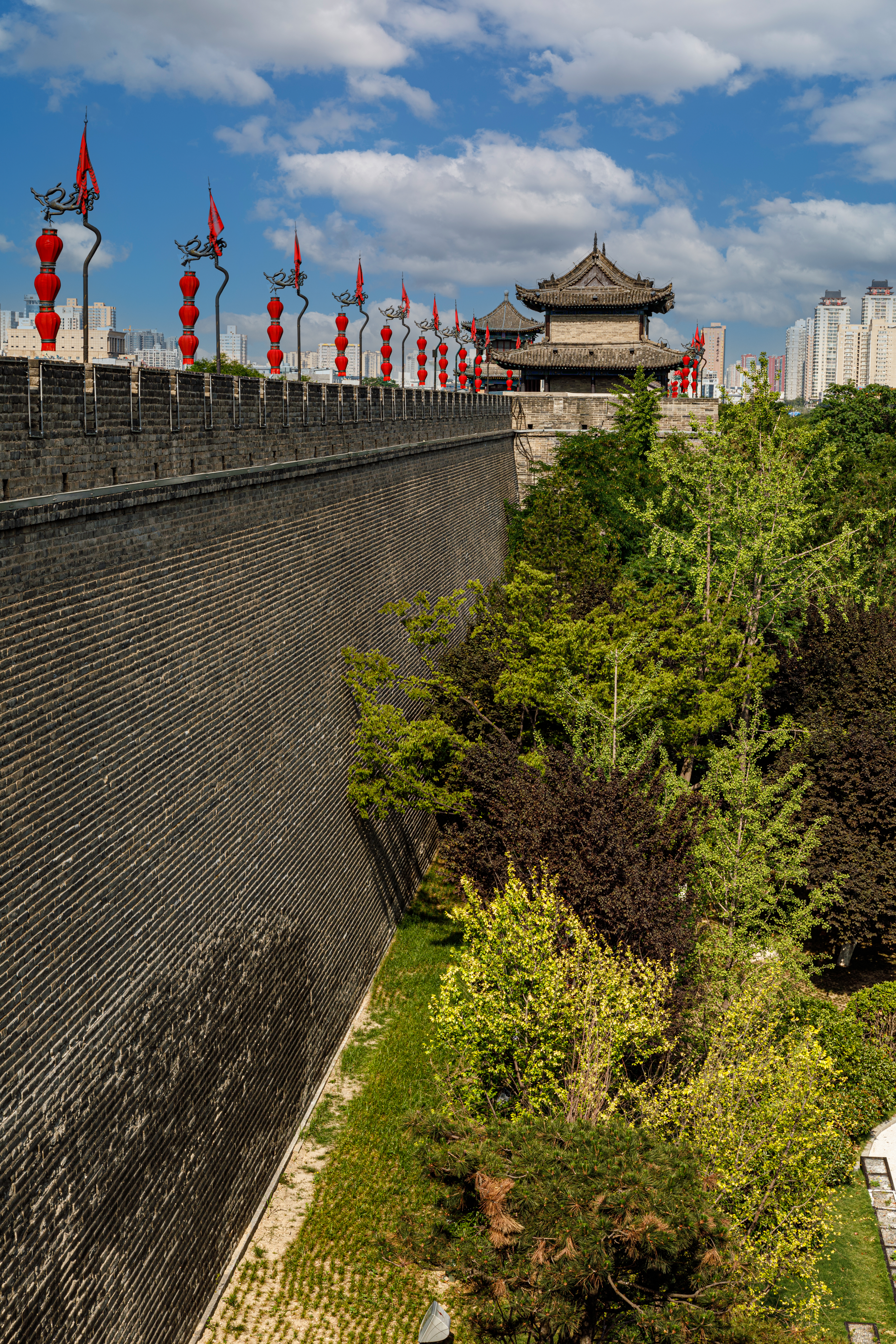 a wall with red lanterns and trees