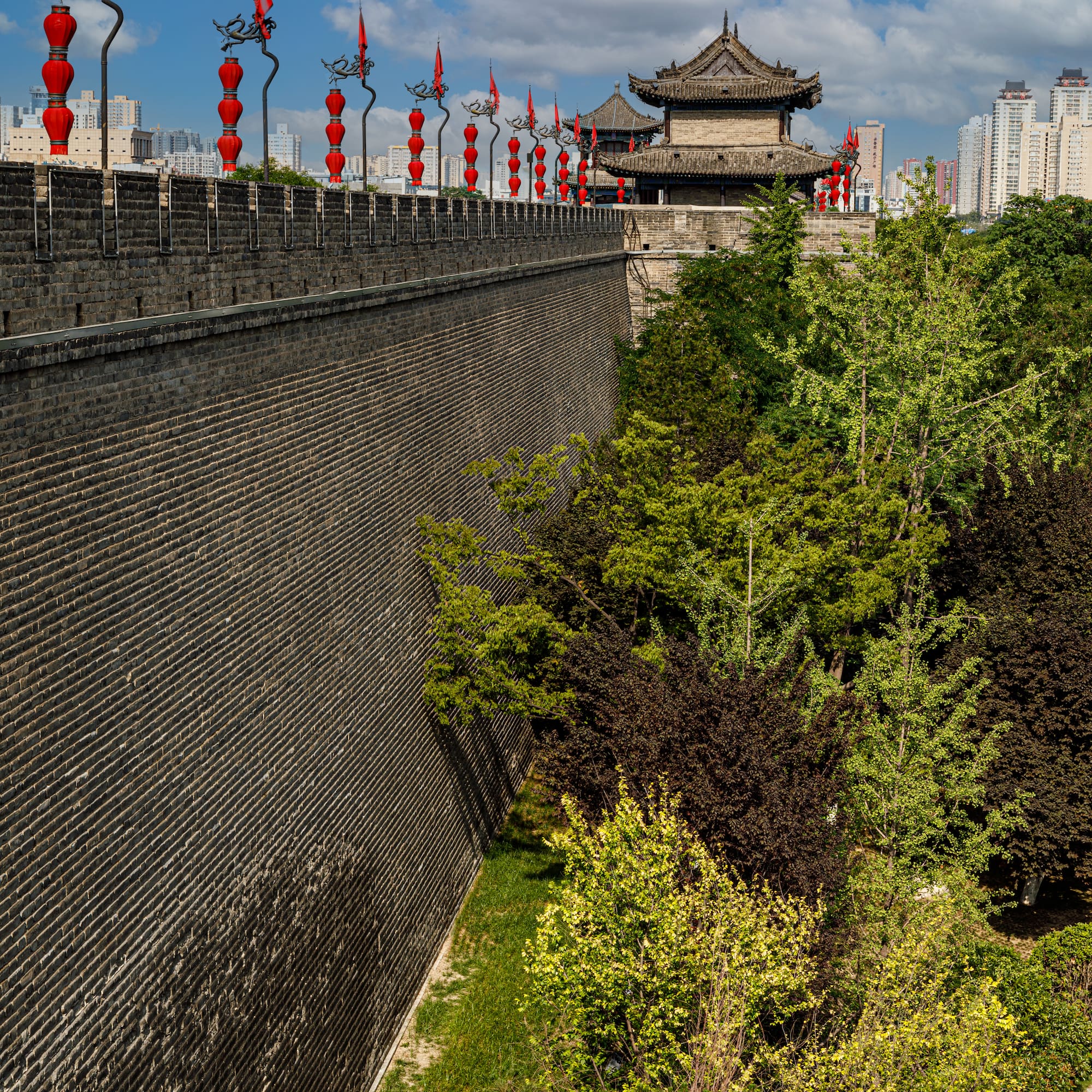 a wall with red lanterns and trees