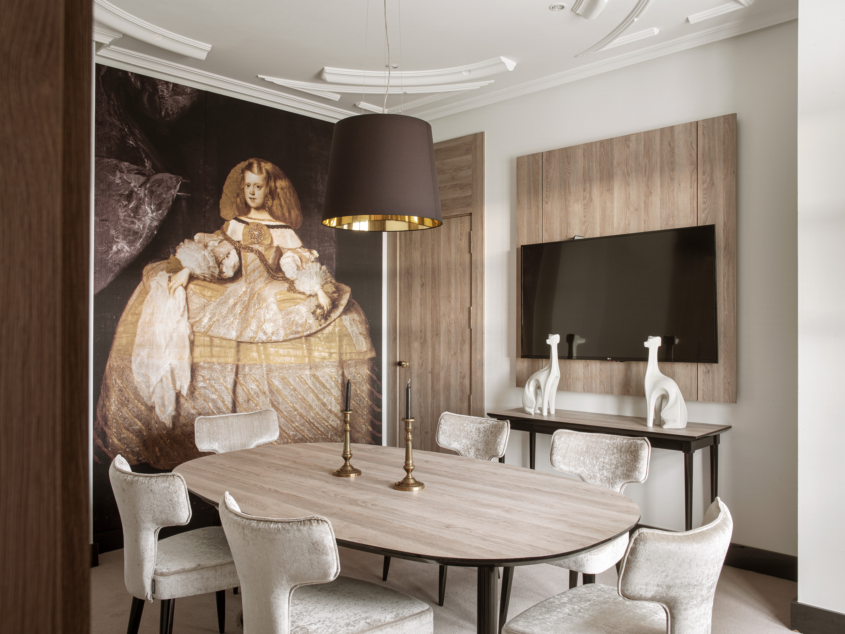 Modern dining room with large art mural, oval wood table, velvet chairs.