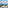 Amber pitcher, two glasses, lemons on a balcony table overlooking a blue ocean.