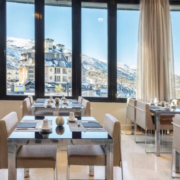 a room with tables and chairs and a view of a snowy mountain