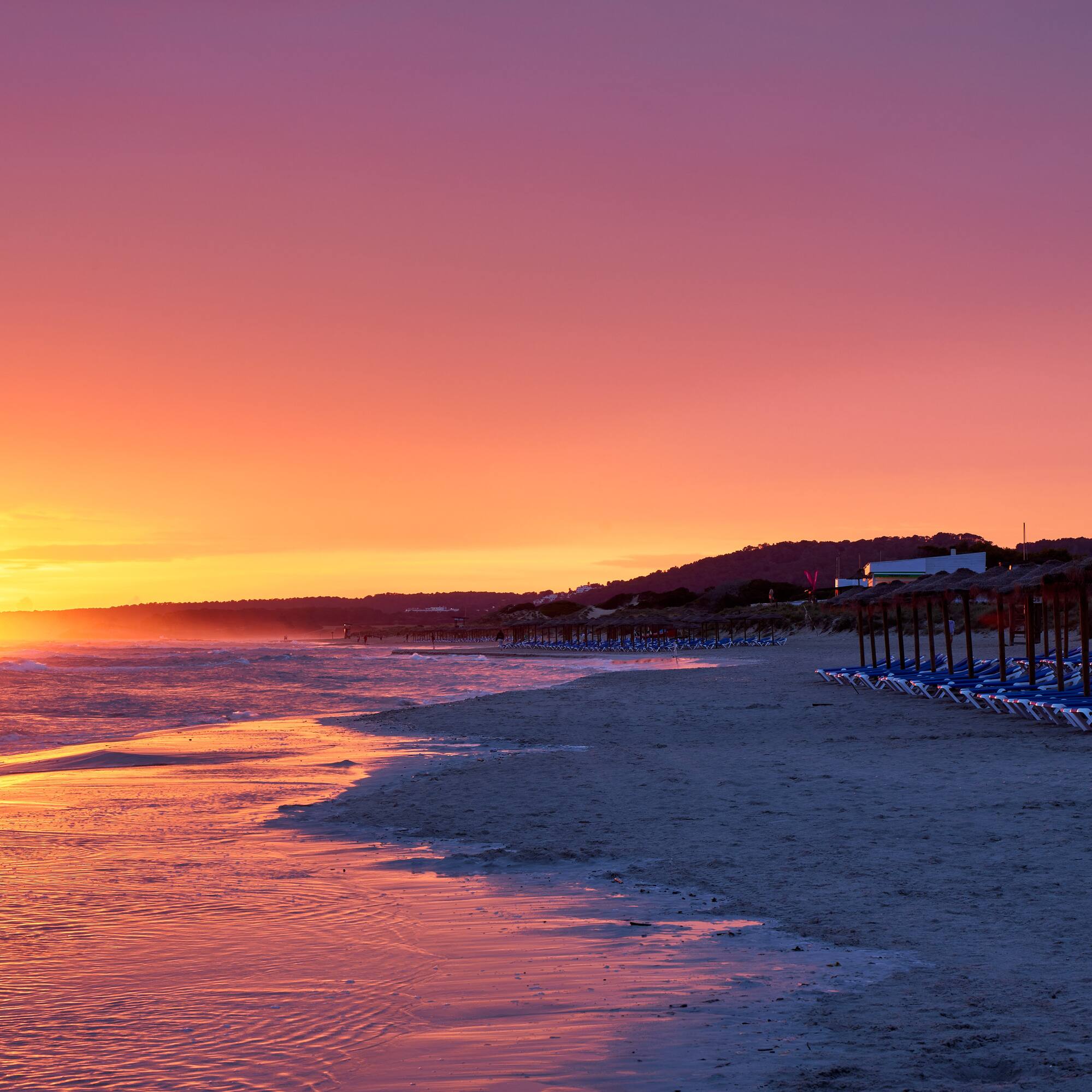 a beach with chairs and umbrellas