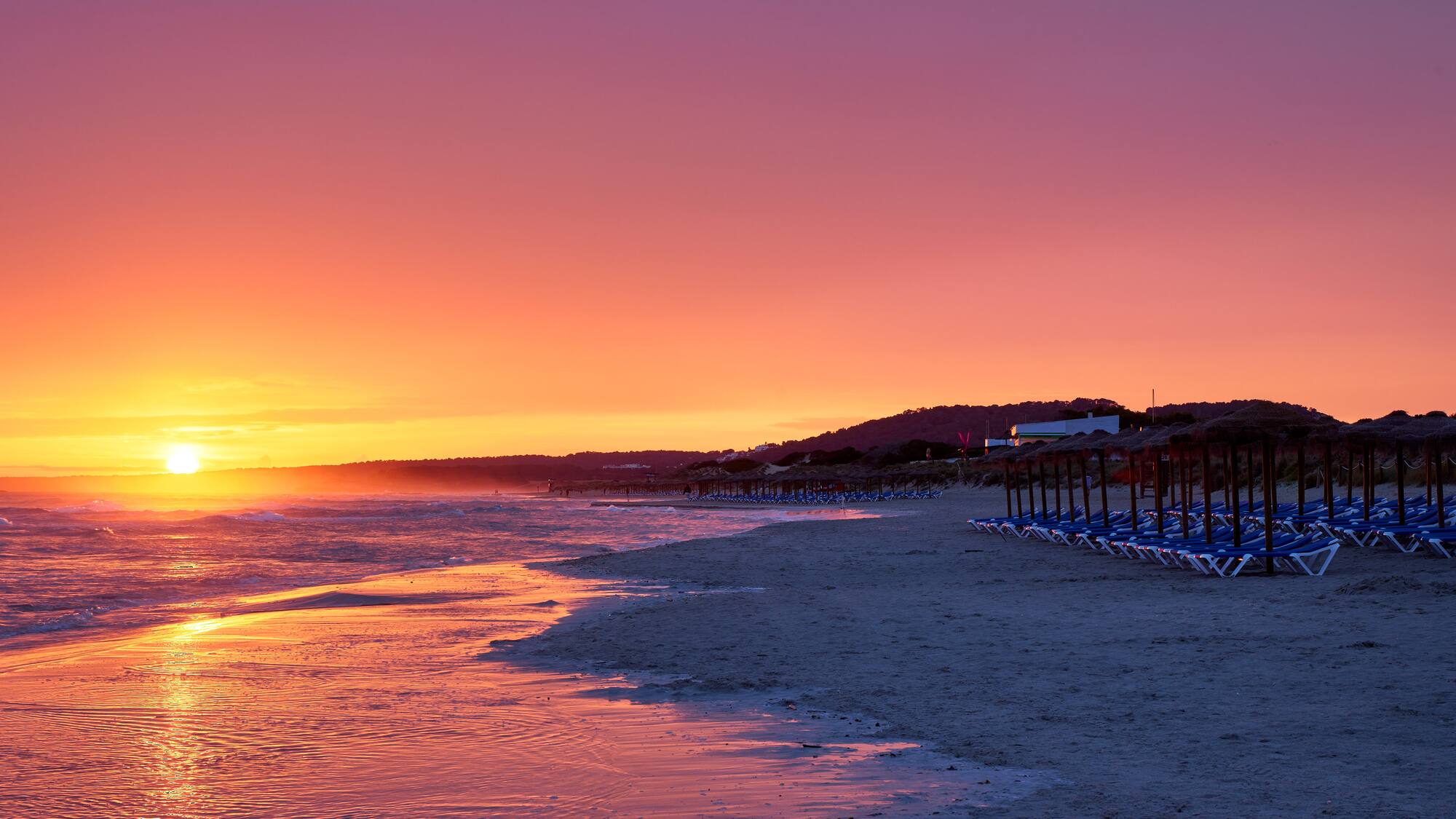 a beach with chairs and umbrellas