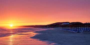 a beach with chairs and umbrellas