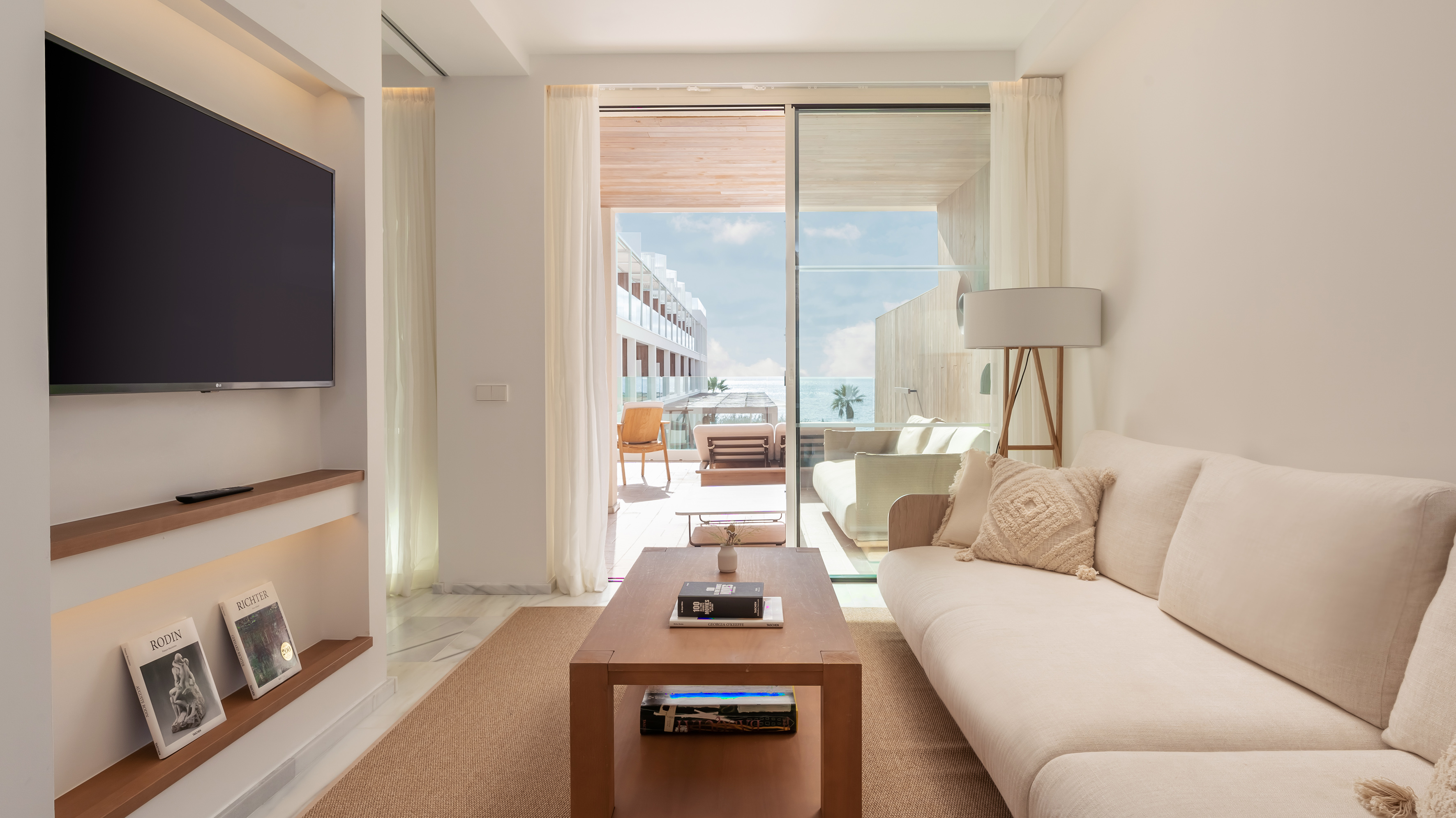 Luxury hotel living room with ocean view balcony and modern sofa.