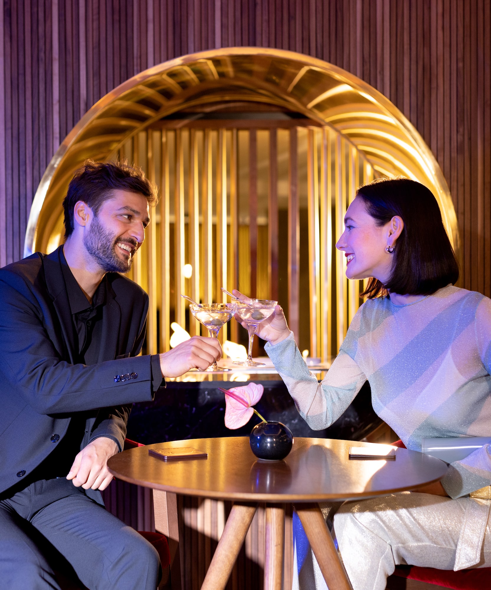 a man and woman sitting at a table with drinks