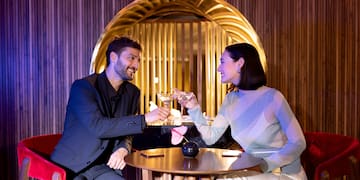 a man and woman sitting at a table with drinks