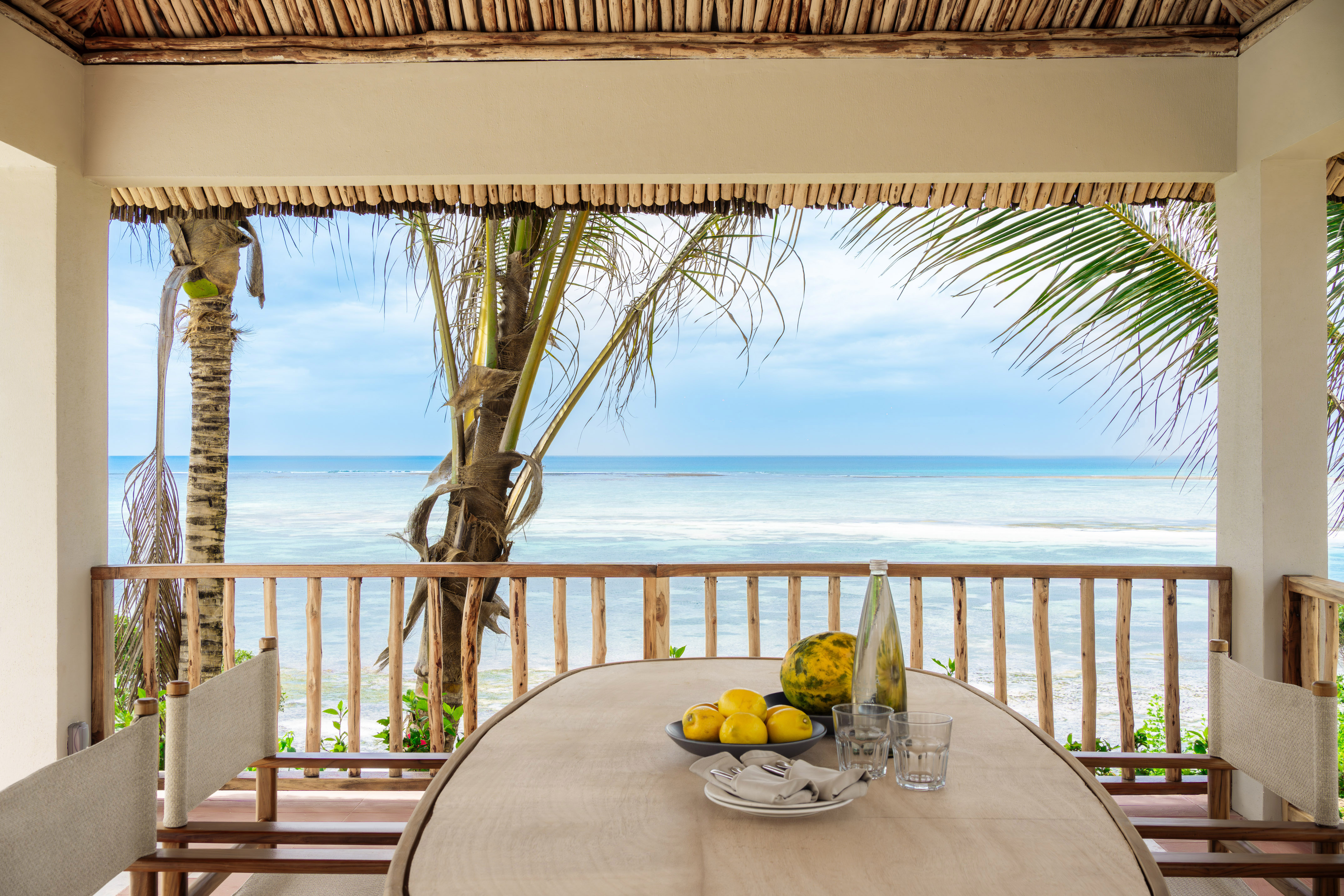Oceanfront balcony dining table with fresh fruit and tropical views.