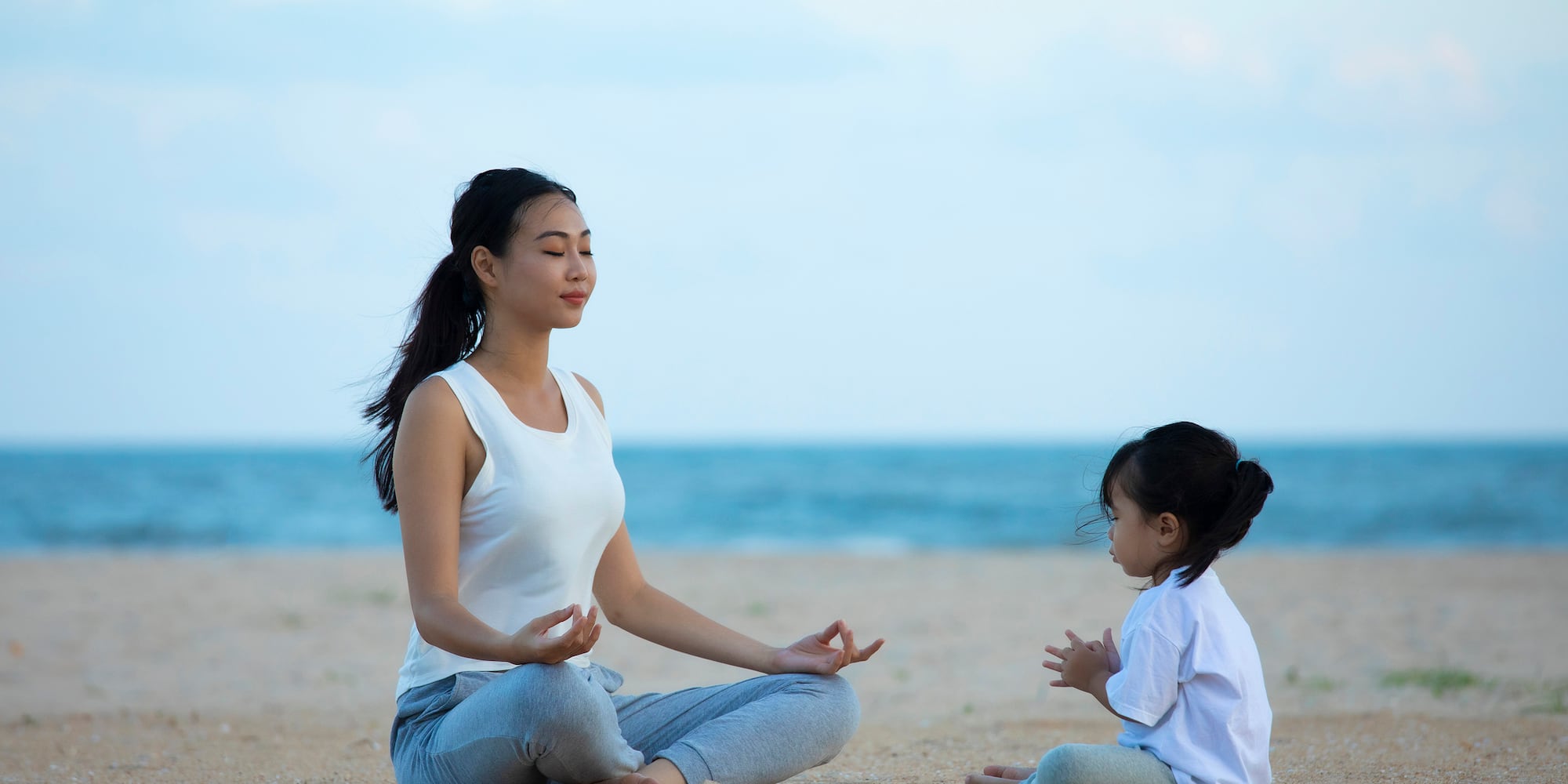 a woman and child sitting on the beach