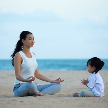 a woman and child sitting on the beach