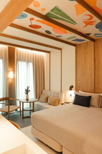 a room with a bed and a table and chairs