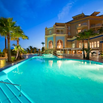 une piscine avec des palmiers et un bâtiment