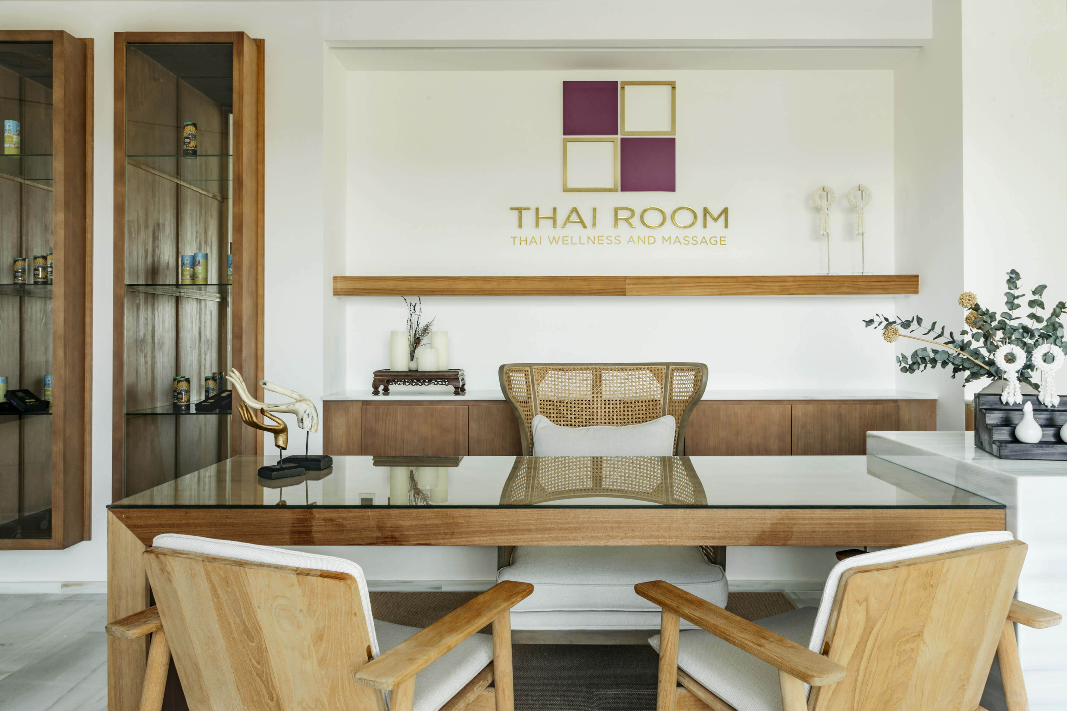 Thai Room wellness & massage spa reception with wooden desk and chairs.