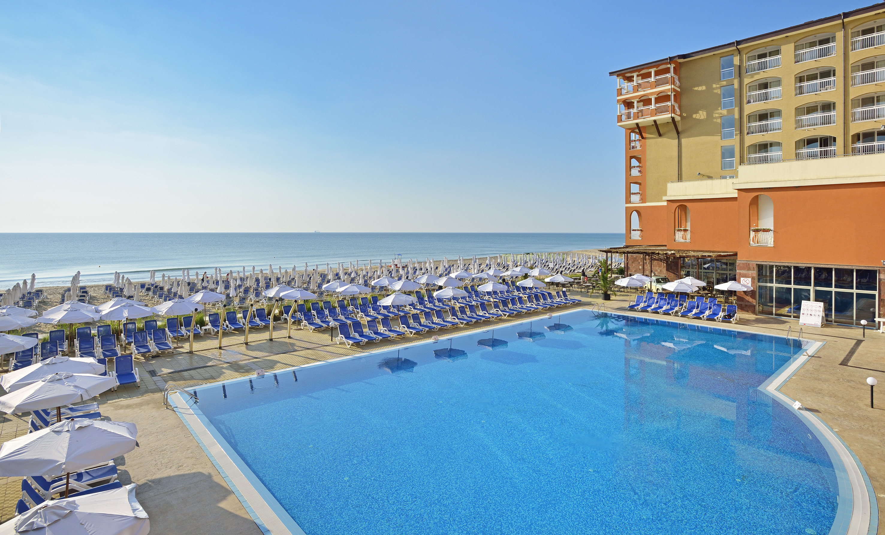 a swimming pool with chairs and umbrellas by a building - SOL Luna Bay, Obzor