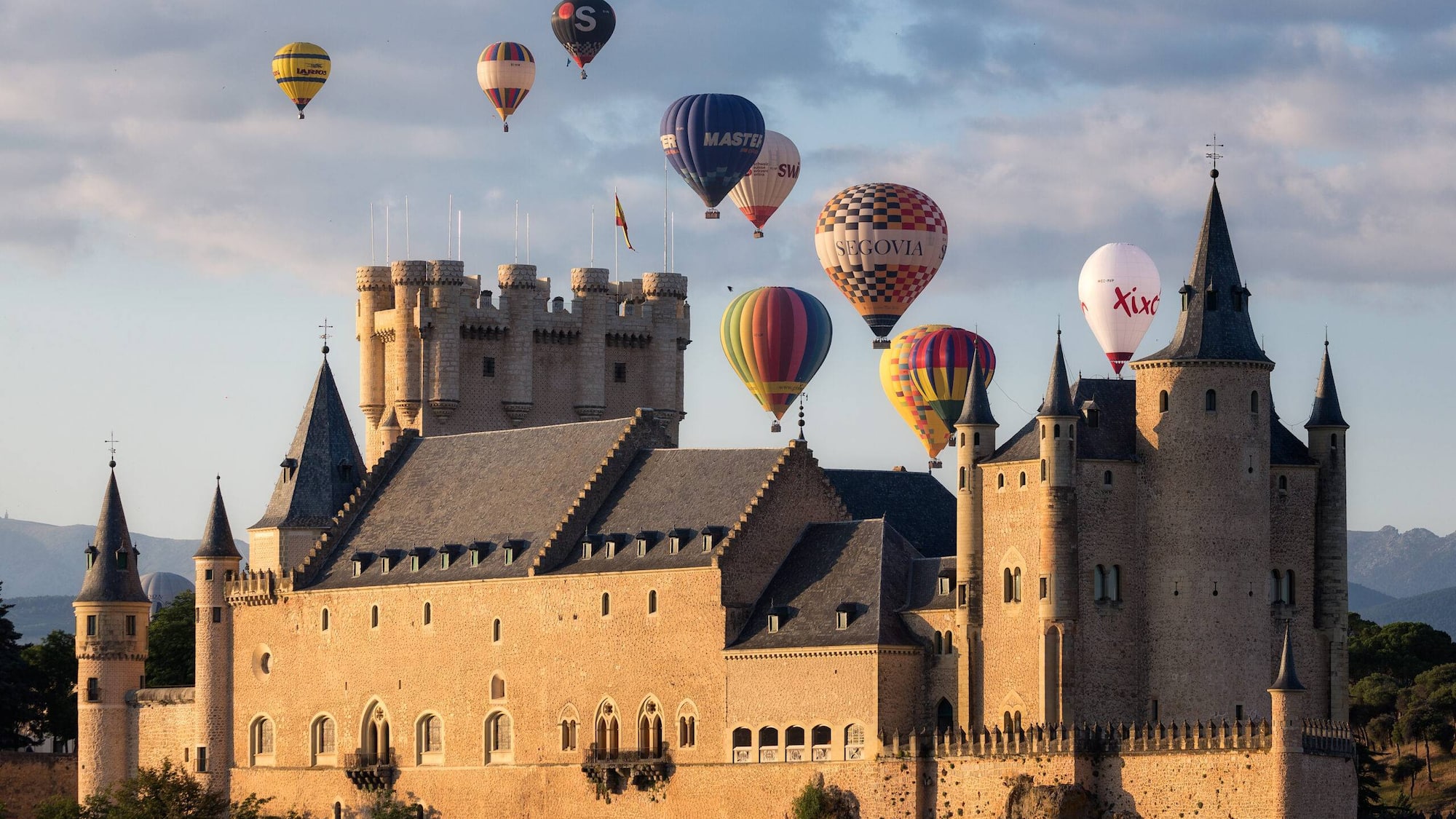 a castle with hot air balloons in the sky