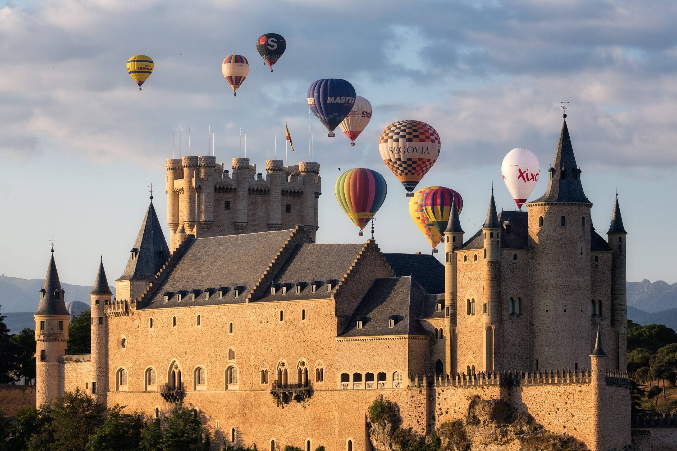 a castle with hot air balloons in the sky
