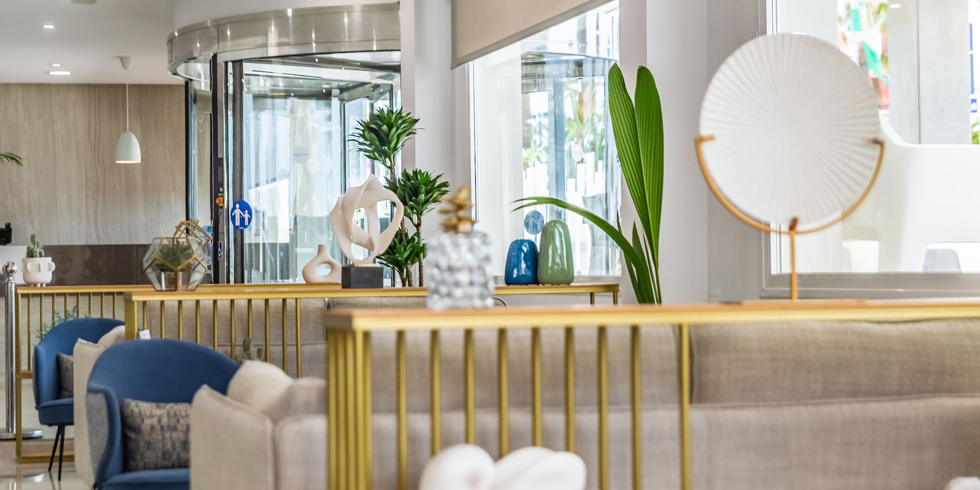 a room with a gold railing and a white and blue vase