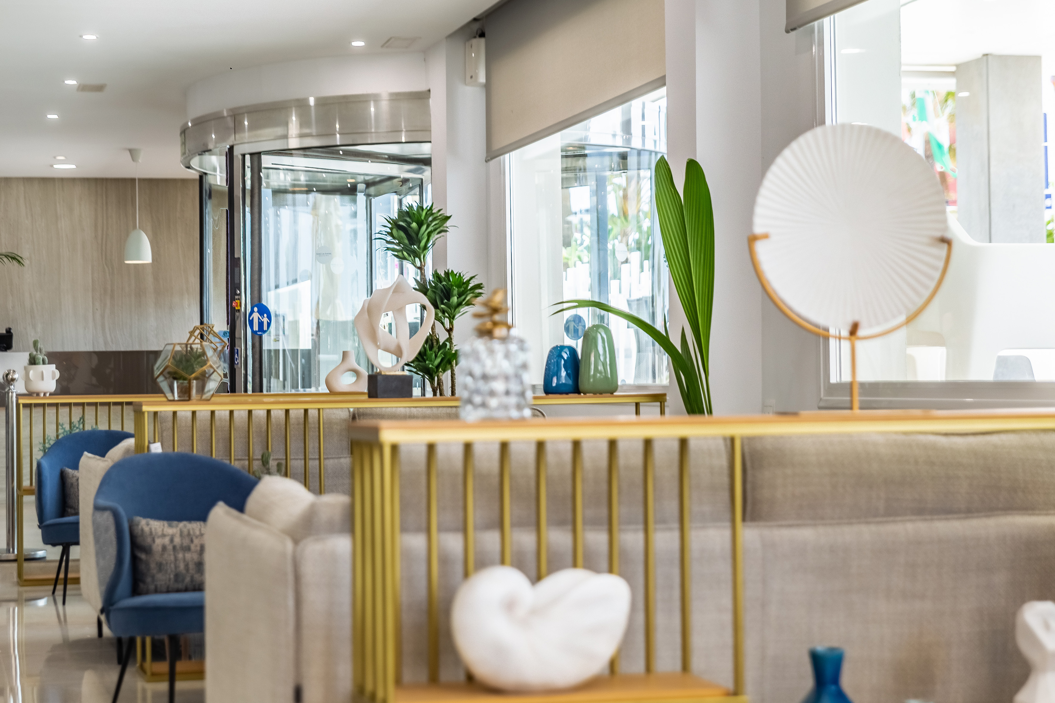 a room with a gold railing and a white and blue vase