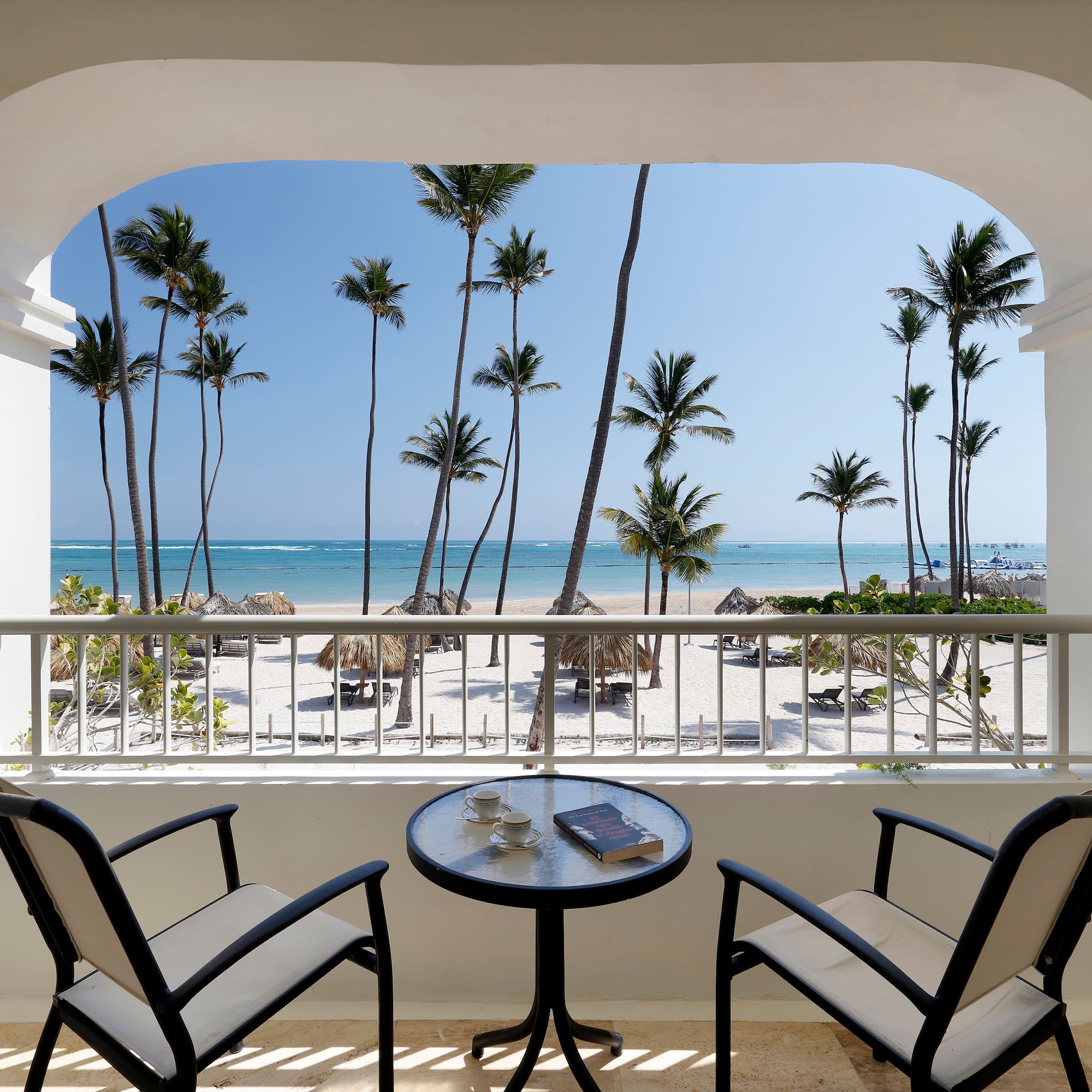 a balcony with a table and chairs overlooking a beach