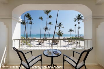 a balcony with a table and chairs overlooking a beach