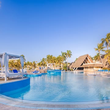 a pool with lounge chairs and a gazebo