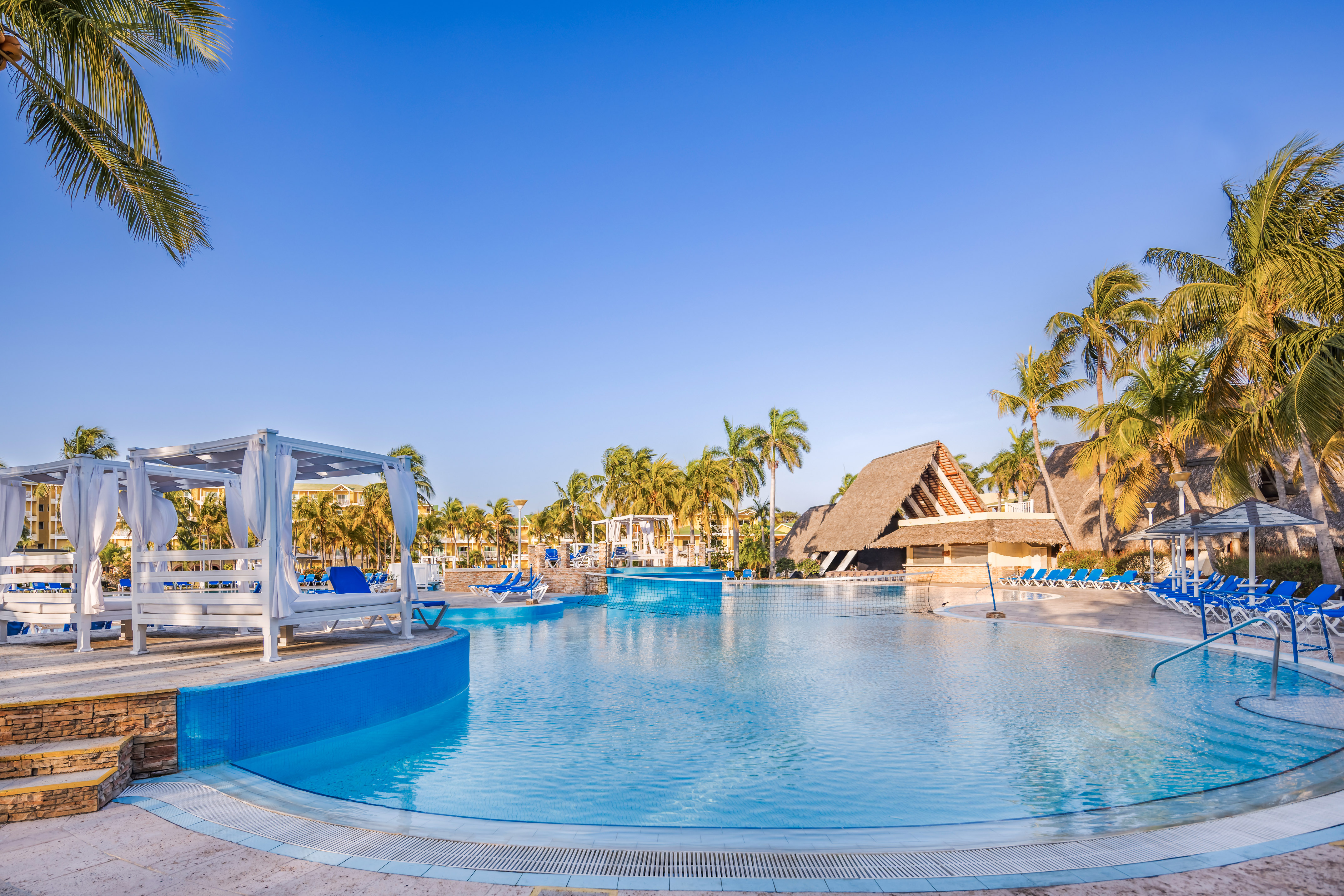 a pool with lounge chairs and a gazebo