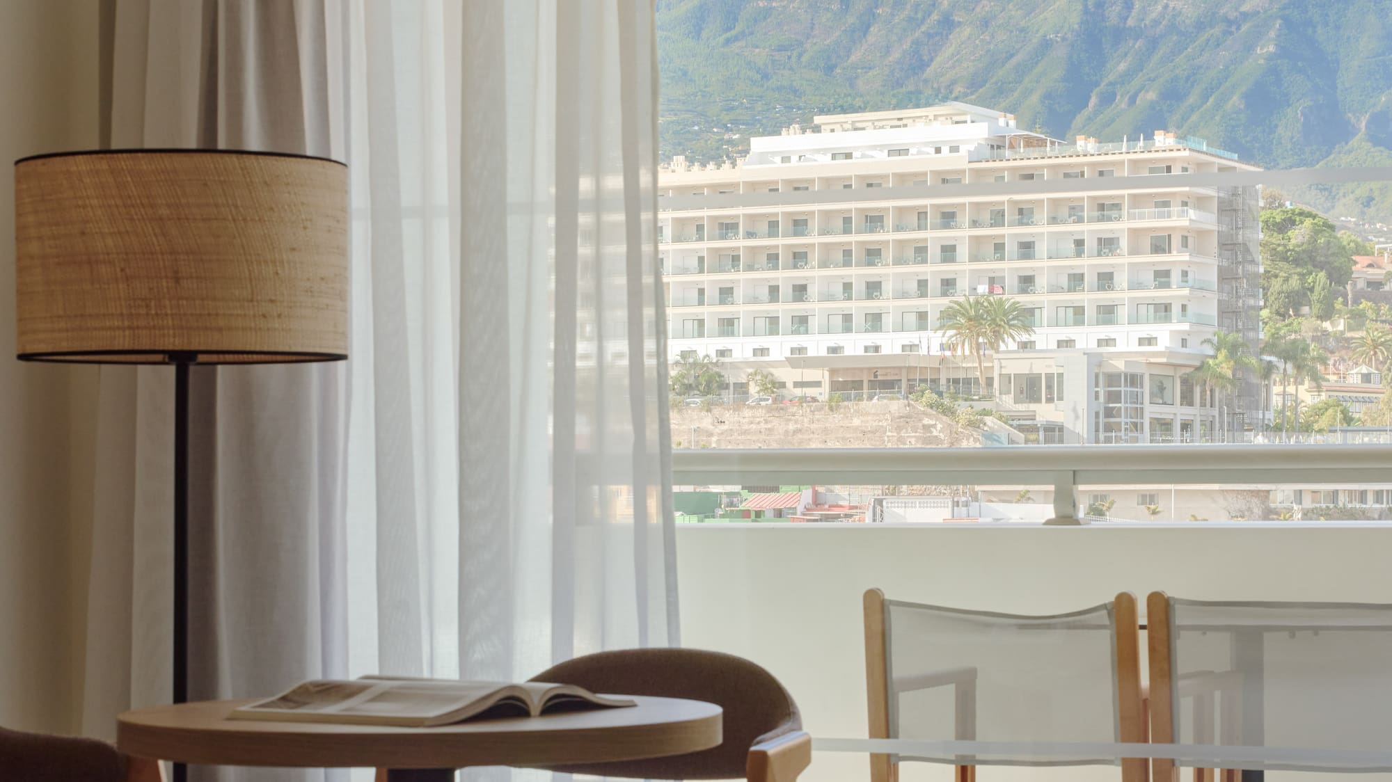 a room with a table and chairs and a lamp