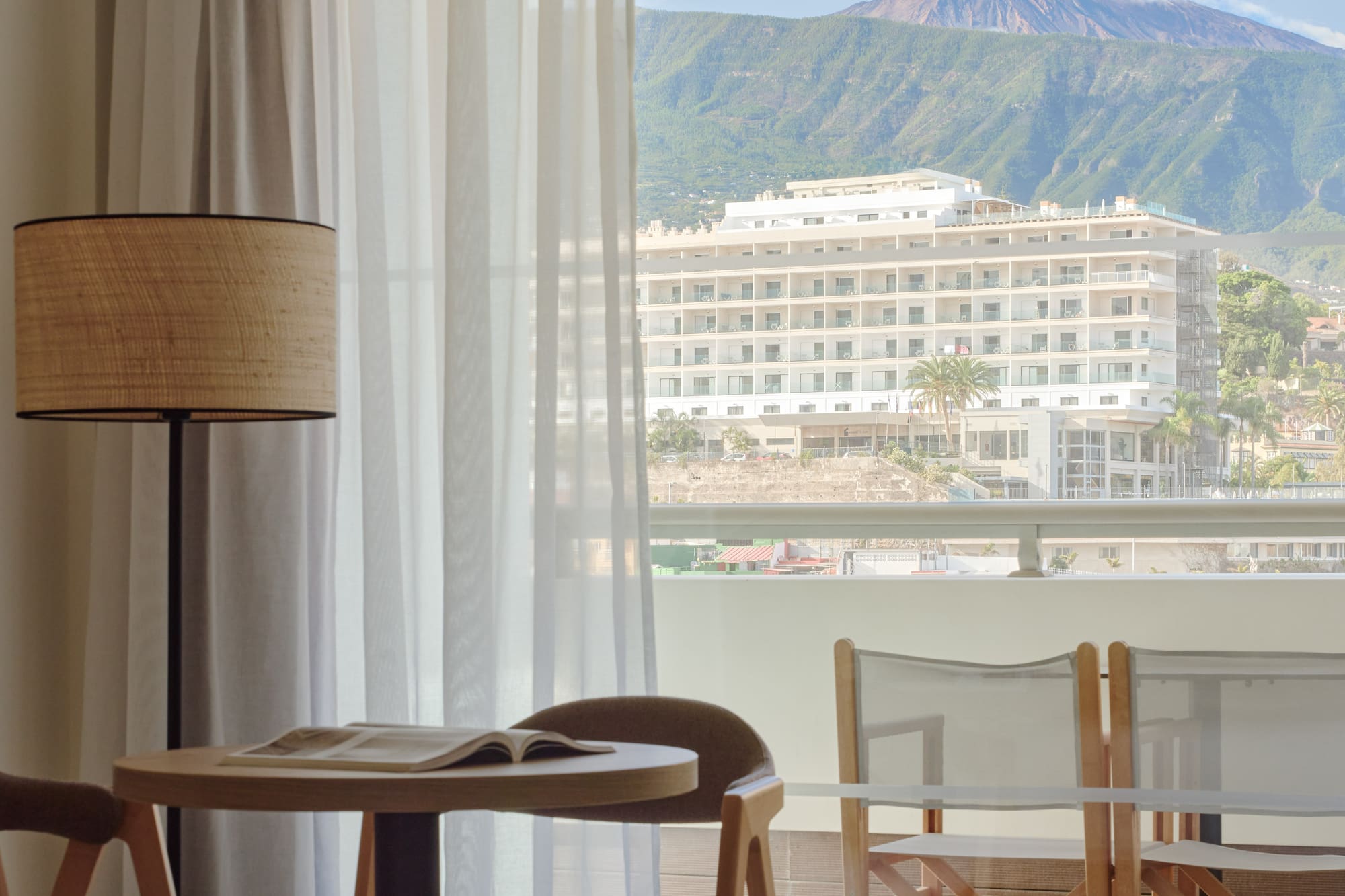 a room with a table and chairs and a lamp