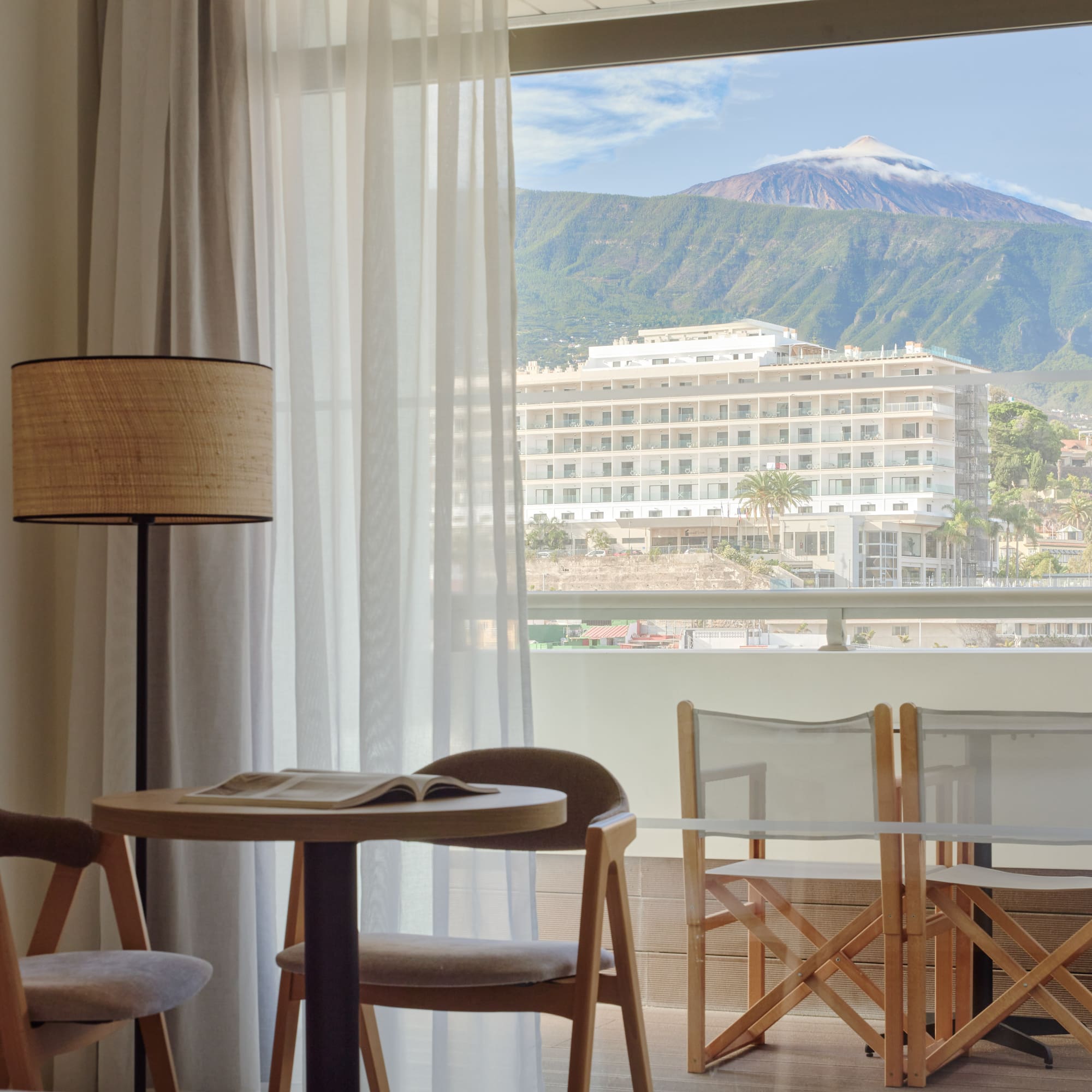 a room with a table and chairs and a lamp