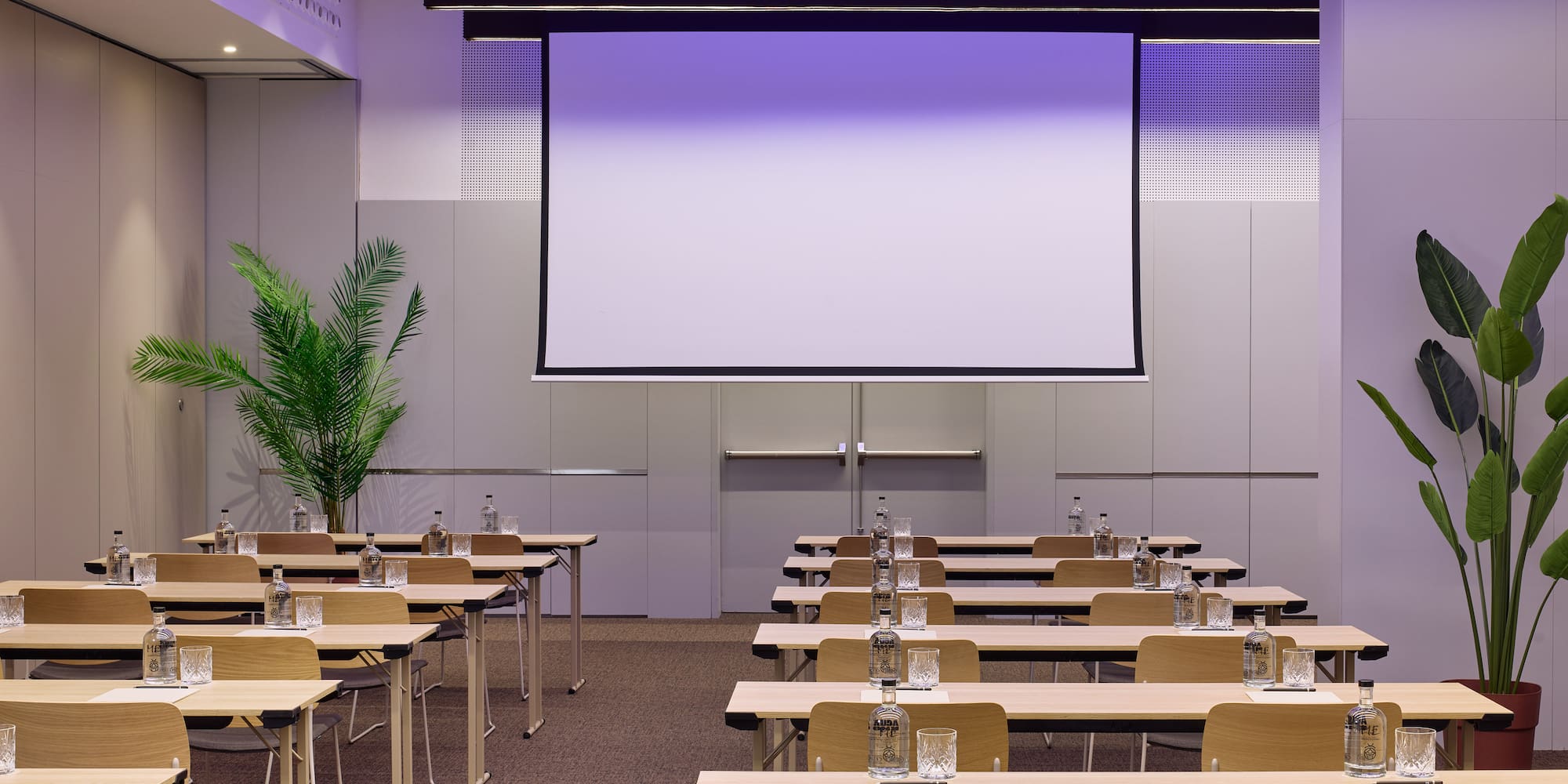 a room with tables and chairs and a projector screen