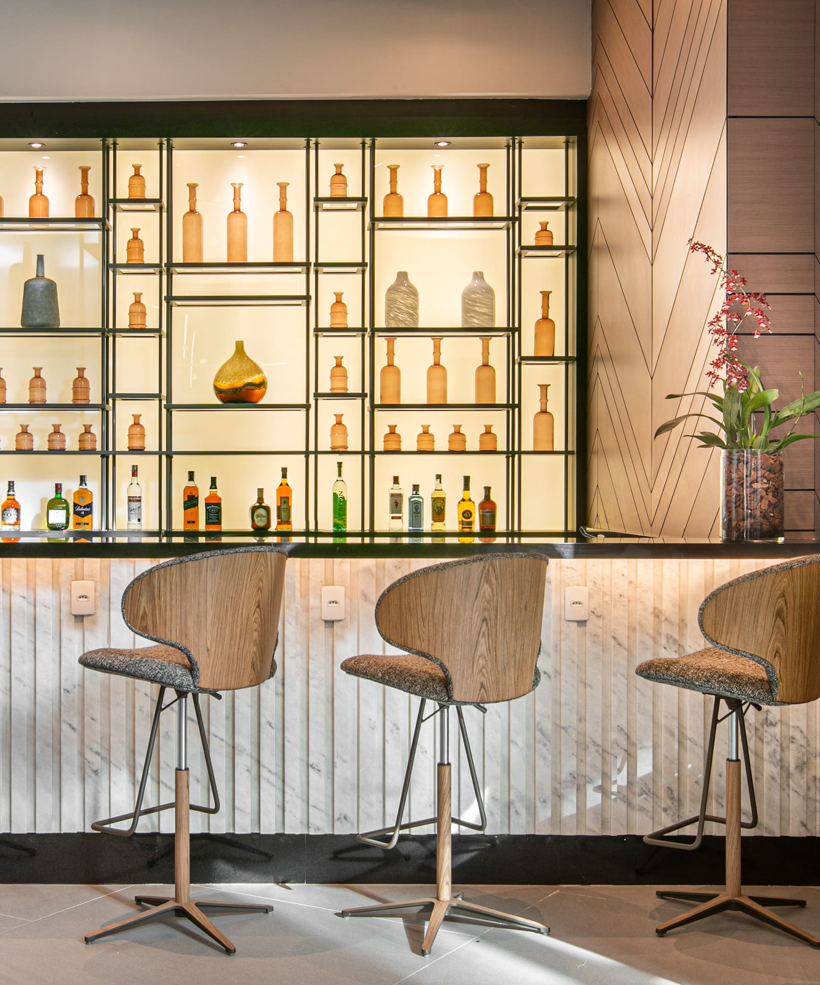 a bar with chairs and bottles on shelves