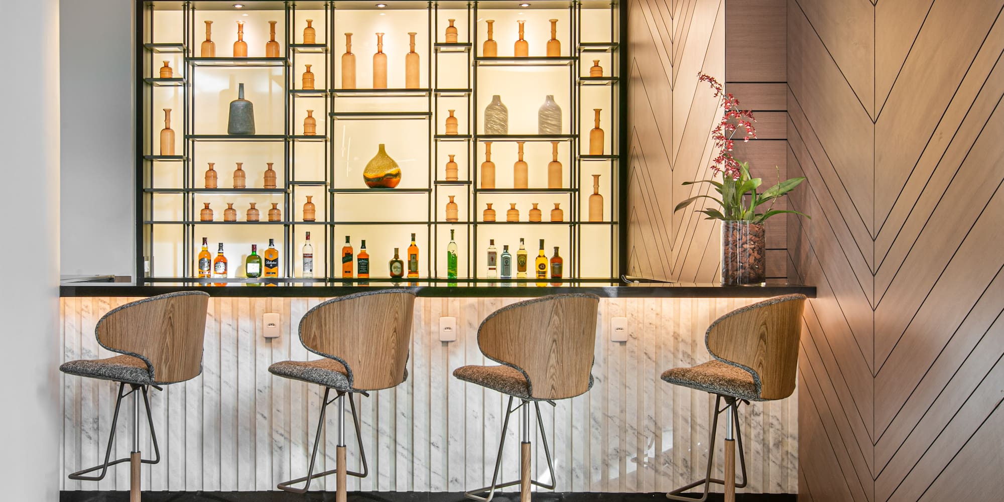 a bar with chairs and bottles on shelves