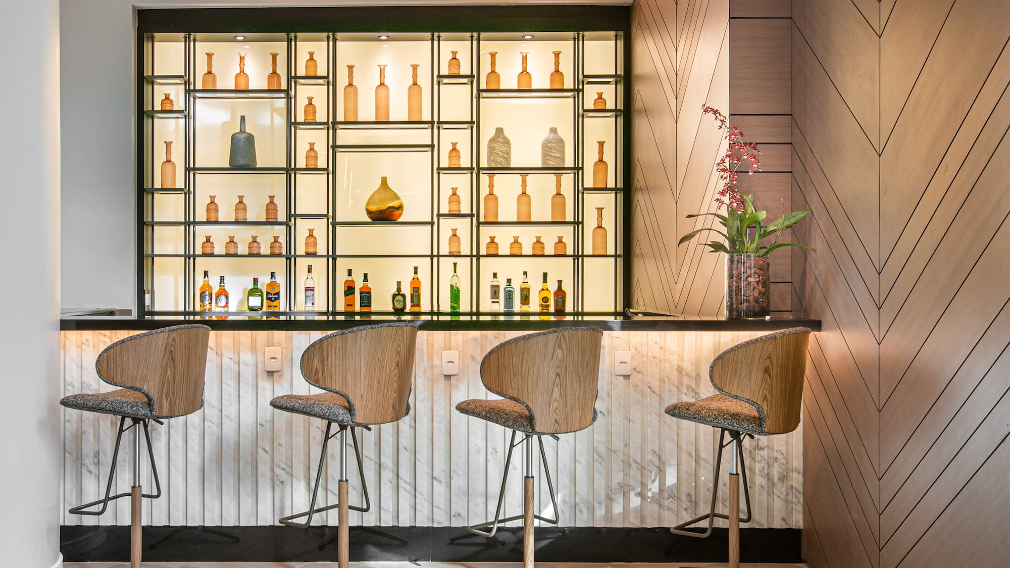a bar with chairs and bottles on shelves
