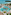 Luxury tropical resort pool, palm trees, sandy beach, and turquoise ocean.