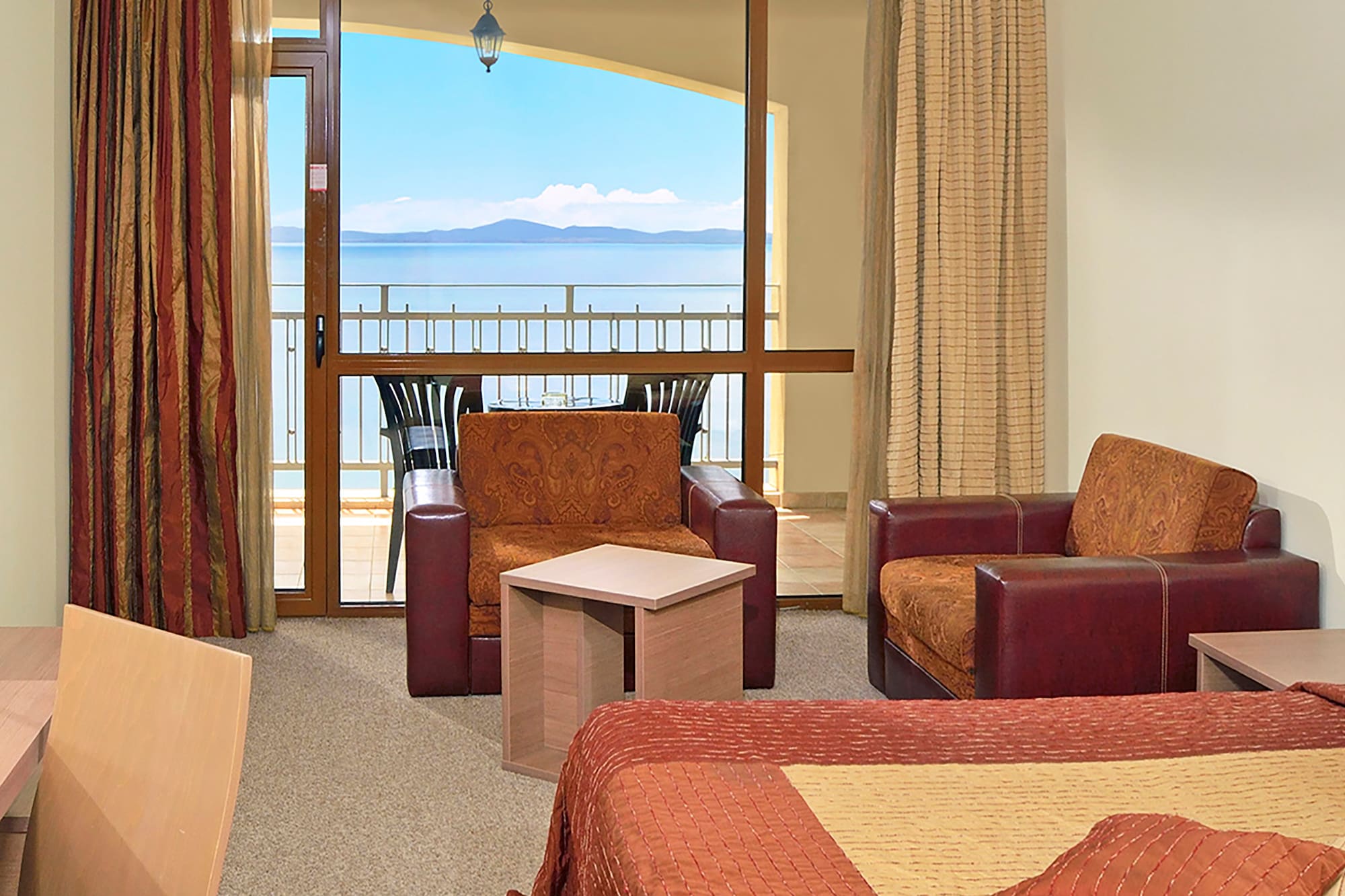 a room with a balcony and a view of the ocean
