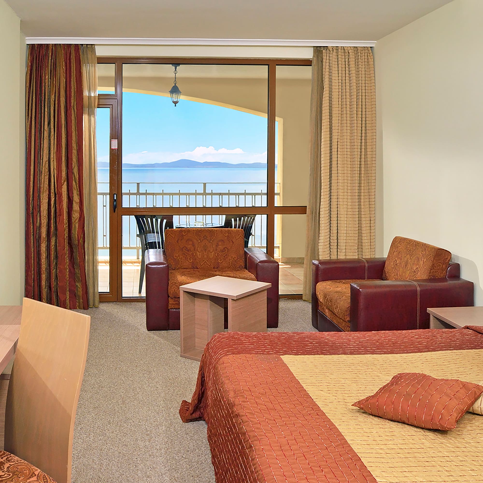 a room with a balcony and a view of the ocean