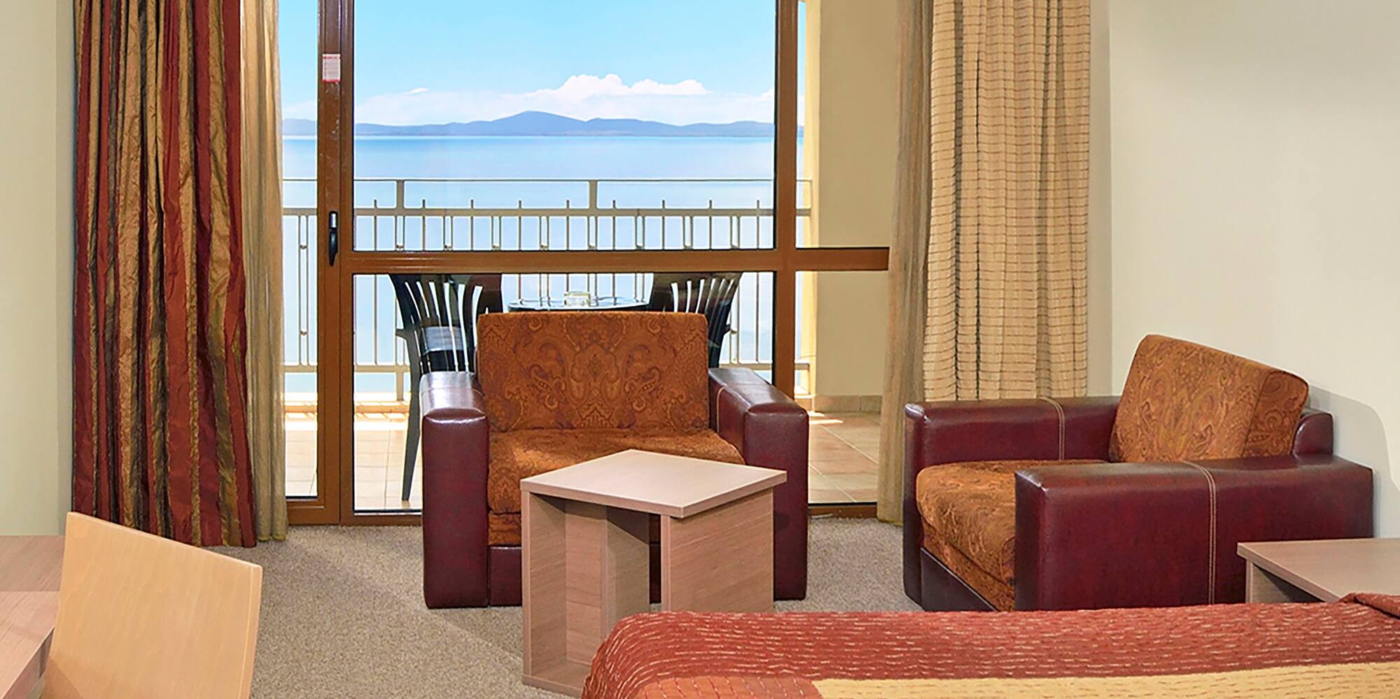 a room with a balcony and a view of the ocean
