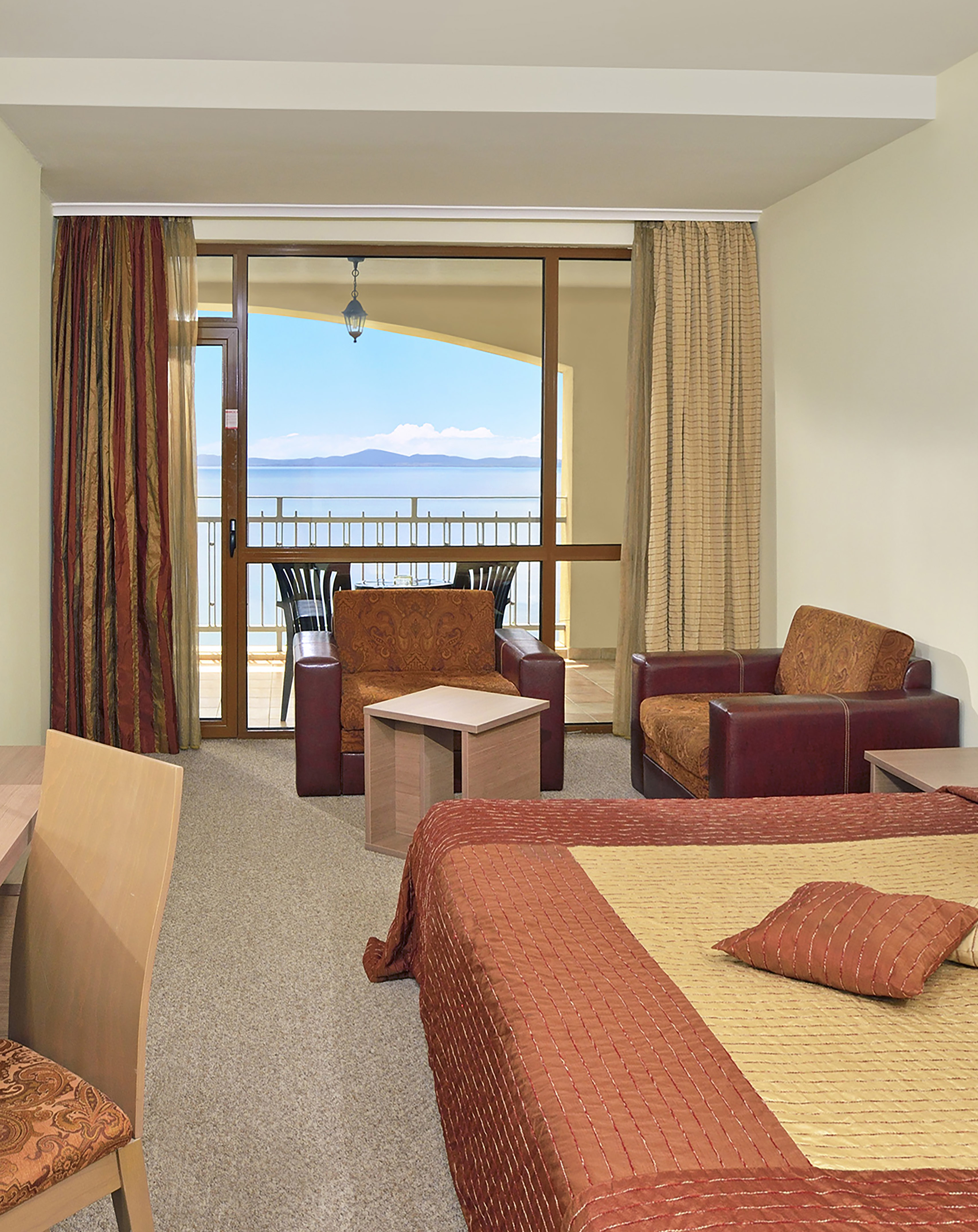 a room with a balcony and a view of the ocean